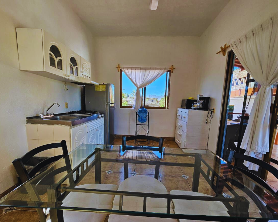 Cocina amueblada integral equipada con utensilios y espacio de comedor en la renta vacacional Casita Loro