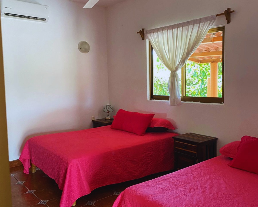 Habitación familiar con aire acondicionado, clóset y dos camas en el bungalow Casita Equino