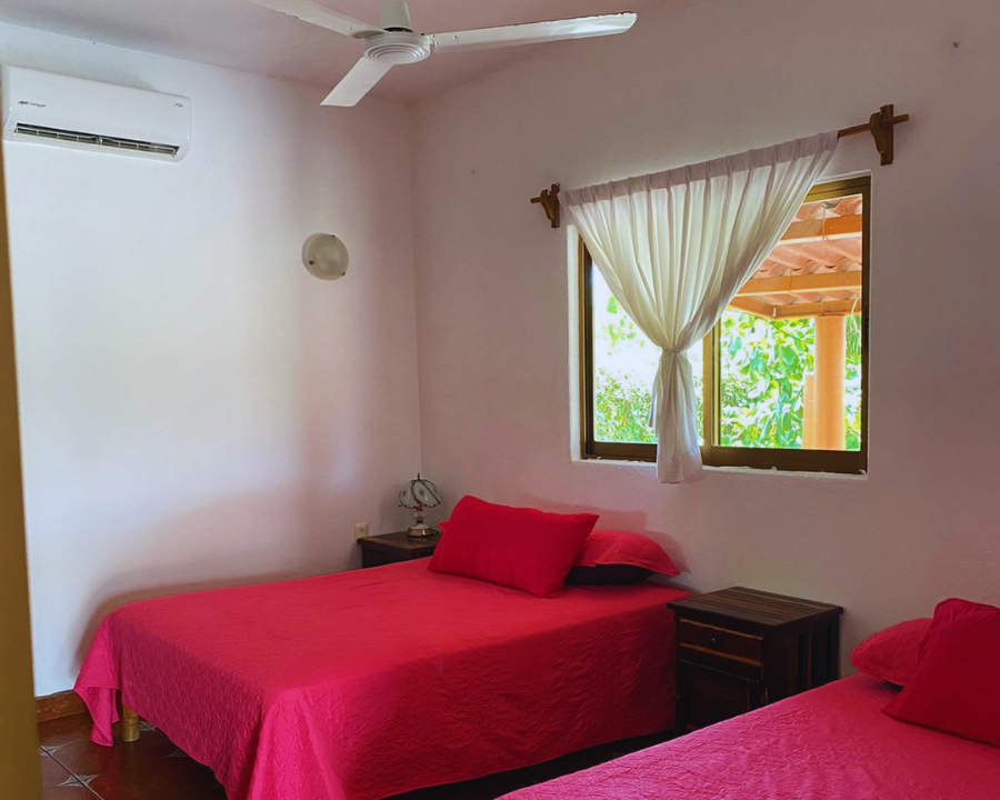 Habitación con dos camas matrimoniales y aire acondicionado