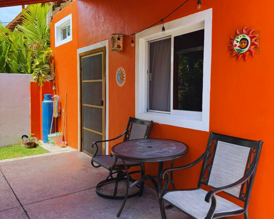 Terraza exterior con dos sillas y una pequeña mesa frente al bungalow